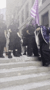 a group of people standing on a set of stairs with the word kc on the sidewalk