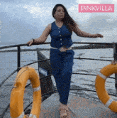 a woman standing on a boat with pinkvilla written on the bottom