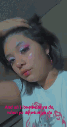 a girl with pink eyeshadow is wearing a white shirt and earrings