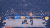 two men are wrestling in a wrestling ring and one is kneeling down