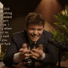 a man sitting at a table with a mug that says af