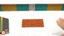 a person is playing with a bunch of magnet beads on a table