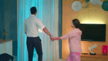 a man and woman holding hands in a living room