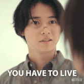 a man with a bandage on his nose looks at a woman and says " you have to live "