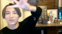 a man in a black shirt is standing in front of a sign that says ' shots ' on it