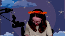 a woman wearing glasses and a headband with tiger ears is sitting in front of a microphone