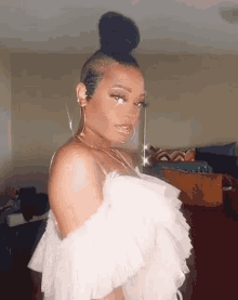 a woman is wearing a white off the shoulder top