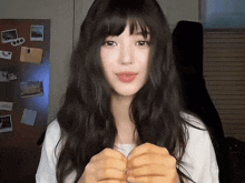 a woman with long black hair and a white shirt has the name njsjaerie written on the bottom of her shirt