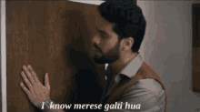 a man leaning against a door with the words i know merese gali hua written on the bottom