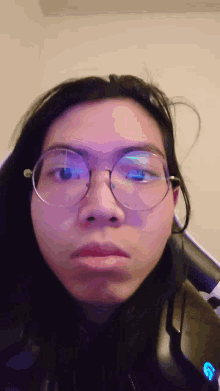 a close up of a person wearing glasses with the letter g in the corner