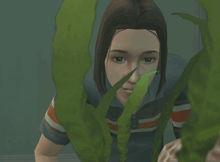 a girl in a striped shirt is peeking through a plant