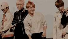 a group of young men are standing next to each other and one of them is kneeling down .