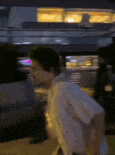 a blurry picture of a man walking down a street at night