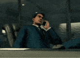 a man in a suit and tie is talking on a cellphone