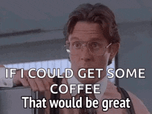 a man in a suit and tie is standing in front of a refrigerator and talking about coffee .