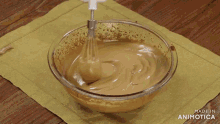 a person is mixing something in a glass bowl that says made in animotica on the bottom