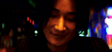 a close up of a woman 's face with a blurry background and a sign that says ' a ' on it