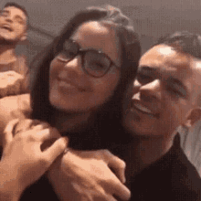 a man and a woman are hugging each other and smiling for a picture .
