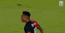 a soccer player wearing a red and black jersey that says plus art