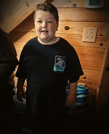a boy wearing a black shirt with a picture of a turtle on it