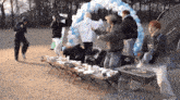 a group of people are standing around a table with balloons .
