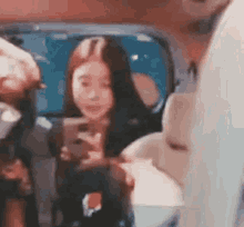 a woman is taking a picture of herself in a mirror while sitting in a car .