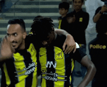 two soccer players are hugging each other and one has a shirt that says roshn on it