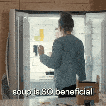 a woman reaches into a refrigerator with the words soup is so beneficial below her