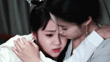 a woman is comforting another woman who is crying with her hand on her forehead