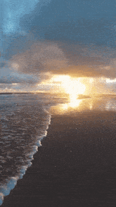 the sun is setting over the ocean with waves crashing on the beach