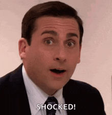michael scott from the office is making a surprised face and saying `` shocked '' .