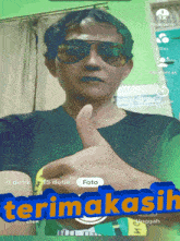 a man wearing sunglasses is giving a thumbs up with the words terima kasih written below him