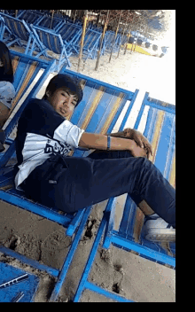 a young man laying on a beach chair with a shirt that says ' boys '