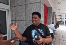 a man wearing a black shirt with a picture of a man on it is smiling