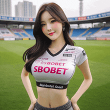 a woman wearing a sbobet shirt is standing on a soccer field