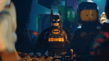 a lego batman is standing next to a lego ninjago batman