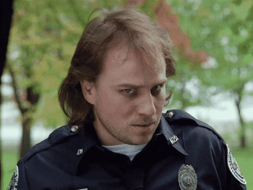 a man in a police uniform has a badge that says ' justice ' on it