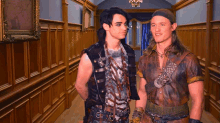 two men are standing next to each other in a hallway and one is wearing a headband