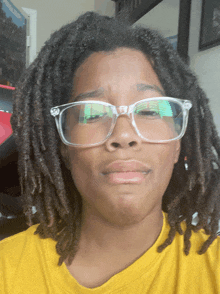 a person with dreadlocks wearing clear glasses