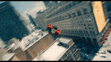 a man in a superman costume is flying through the air above a city