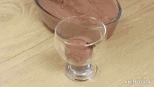 a glass of chocolate ice cream is being poured into it
