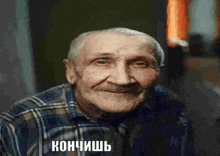an elderly man in a plaid shirt is smiling in a russian language