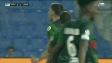 a soccer player wearing number 14 talks to another player