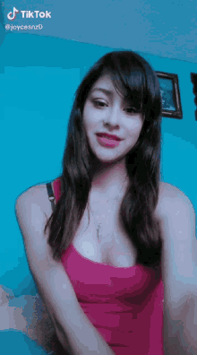 a woman in a red tank top has a tiktok sticker on her face