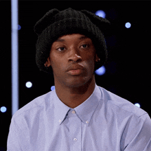 a man wearing a black beanie and a blue shirt