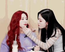 a girl with red hair is feeding another girl with chopsticks and a bottle of milk in the background