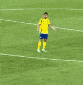 a soccer player wearing a yellow kafc jersey