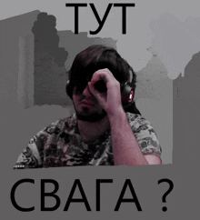 a man wearing headphones and sunglasses is behind a sign that says cbaga