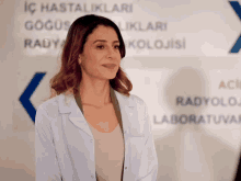 a woman in a lab coat is standing in front of a sign that says aci radyolog laboratuvar