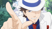 a man wearing a white suit and a blue hat is pointing his finger
